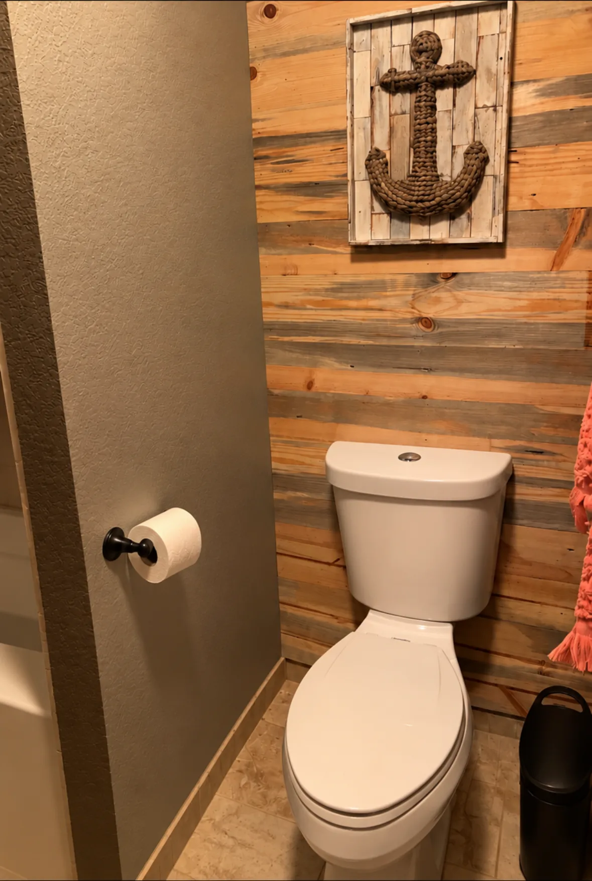 Full bathroom with reclaimed wood wall and anchor wall art